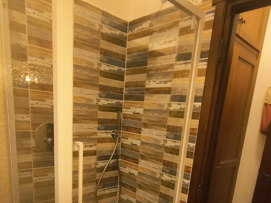 Doccia finita con box e piastrelle effetto legno, a Vigevano